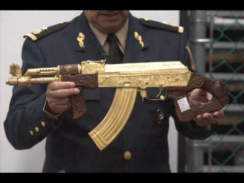Un oficial de uniforme sostiene un fusil de asalto dorado